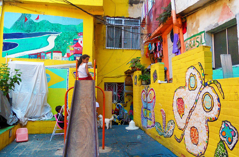 A courtyard covered in bright mural in a narrow lane of Rocinha