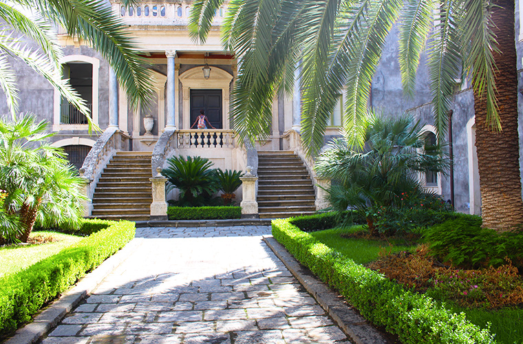 Meltingsisters - the volcanic city of Sicily - palm trees and the entrance to an estate home