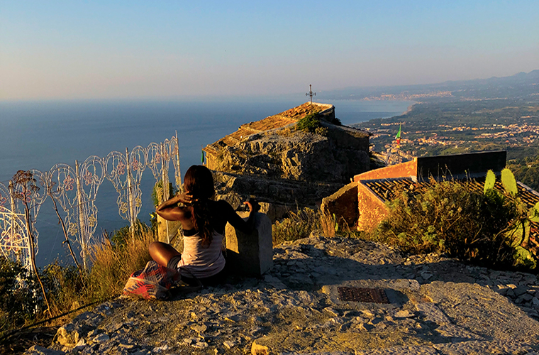 Meltingsisters - road trip across Sicily - a girl sitting on a rock overlooking the landscape below